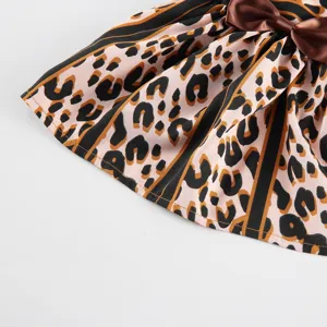 Close-up detail of pet summer skirt with chic leopard print, black stripe borders and satin bow.