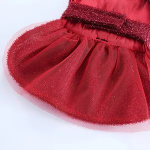 Gros plan robe de chien rouge en tulle avec ceinture scintillante pour fête de mariage.