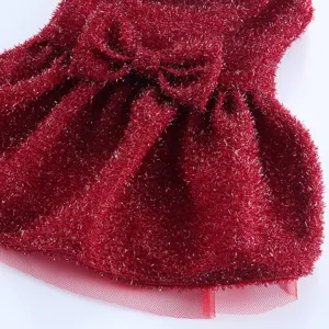 Gros plan détail d'une robe de chien rouge scintillante avec un nœud papillon élégant.