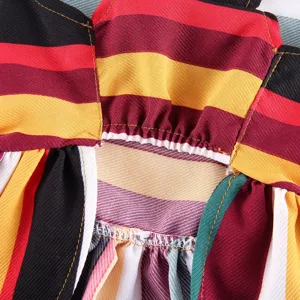 Close up detail of colorful rainbow striped pet dress fabric, fine stitching and pleated design.