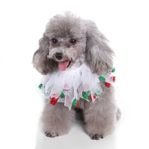 Close-up of a poodle wearing a white mesh pet collar with festive red and green pom-poms