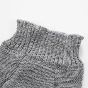 Gros plan sur le col douillet du pull pour animal en tricot gris, texture douce.