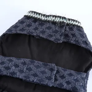 Gros plan de la robe pour chien avec tissu texturé foncé et fermeture velcro sécurisée.