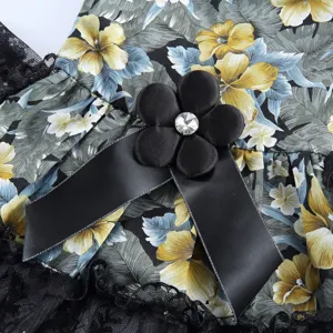 Gros plan détaillé d'une robe pour chien élégante avec imprimé floral, dentelle et nœud.