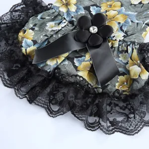 Détail de robe pour animal avec imprimé floral tropical, bordure en dentelle et nœud.