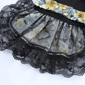 Gros plan détail de robe pour chien en dentelle noire résille et ceinture florale style.
