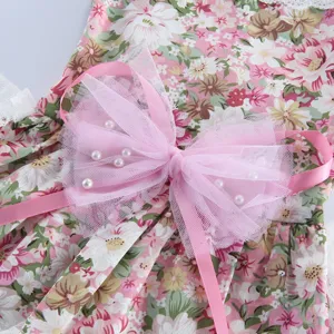Vue détaillée d'une robe de chien à fleurs roses avec grand nœud en tulle et perles.