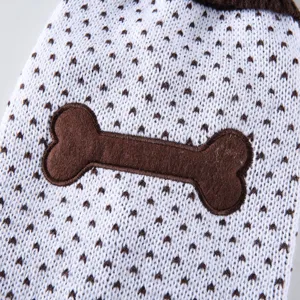 Gros plan détail du pull tricoté d'hiver pour animal avec joli patch d'os marron et texture.