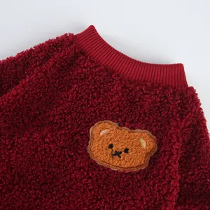 Primo piano dettaglio di morbido abbigliamento in pile per animali con toppa di orsetto.