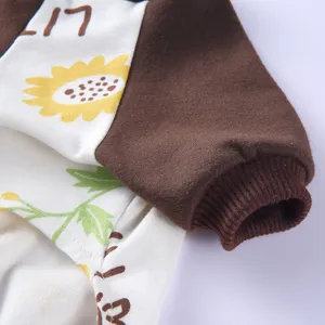 Nahaufnahme des Baumwoll-Tierpyjamas mit Sonnenblumenmuster und geripptem braunem Bündchen