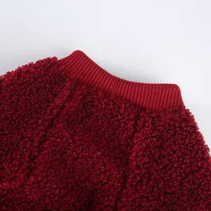 Dettaglio abbigliamento per animali in pile rosso, tessuto termico morbido con colletto a coste.