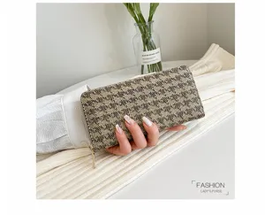 Close-up of a checkered linen women's clutch bag held in hand, showing texture and size.