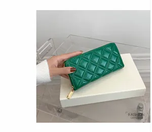Close-up of a green quilted long clutch wallet with glossy finish and gold zipper