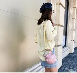 Foto de estilo de vida de un bolso bandolera rosa creativo con forma de baloncesto.