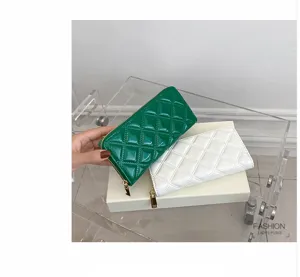 Detailed shot of green and white glossy quilted long wallets featuring gold-tone zippers.