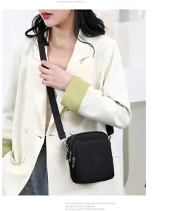 Primer plano de un bolso bandolera pequeño de tela oxford negra en una modelo