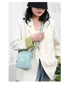 Modelo asiática con un bolso bandolera de tela Oxford verde menta para mujer chic