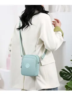 Bolso bandolera pequeño de tela Oxford verde claro llevado por modelo de espalda.