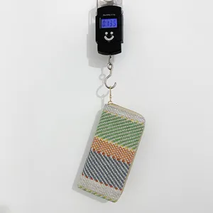 Lightweight linen woven striped clutch wallet for women shown on a digital scale