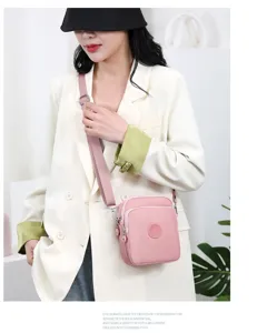 Elegante bolso bandolera rosa de tela Oxford llevado por una modelo en un estilo minimalista