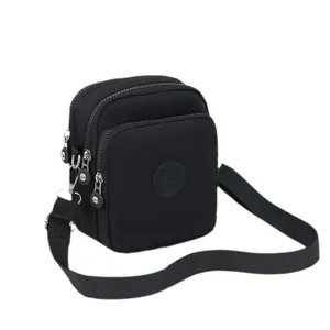 Bolso bandolera compacto de tela Oxford negra para mujer con múltiples compartimentos con cremallera