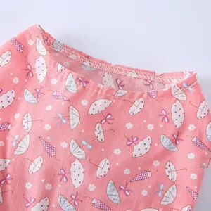 Détail de robe rose mignonne pour animal avec motif parapluie. Tissu doux et respirant.