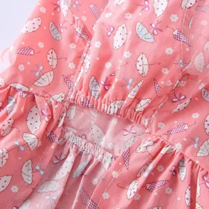 Vue détaillée du tissu de robe pour animal rose avec motif parapluie et belles coutures.