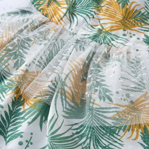 Vue détaillée de la robe pour animal avec motif de feuilles tropicales et volants en tulle blanc.
