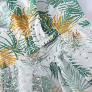 Gros plan sur le tissu de la robe pour animal avec imprimé tropical et bordure en dentelle.