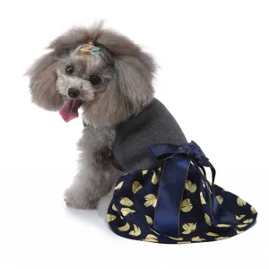 Détail de robe pour chien avec haut gris, jupe imprimée bleue et grand nœud papillon.
