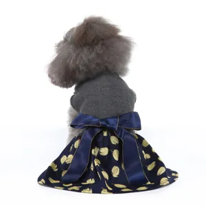 Jolie robe pour chien avec haut en tricot gris, noeud en satin bleu marine et feuilles.