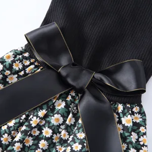 Gros plan détail robe animal avec haut côtelé noir, nœud satin élégant et jupe florale.