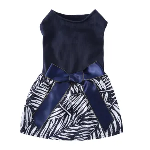 Détail de robe pour animal avec corsage côtelé, jupe imprimée et joli nœud satiné.