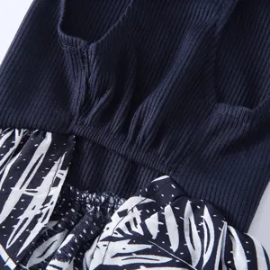 Gros plan détaillé de robe pour animal avec un tricot côtelé bleu et un imprimé végétal.