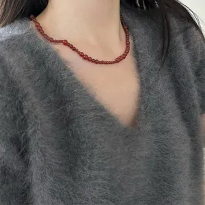 Detailansicht einer roten Achat-Perlenkette im Vintage-Stil an einem Modell