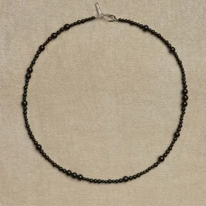 Nahaufnahme einer Vintage-Halskette mit unregelmäßigen schwarzen Onyxperlen und Verschluss