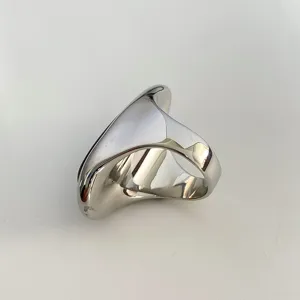 Primo piano di un anello in argento lucido con finitura a specchio e design fluido