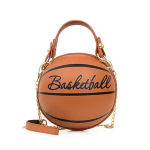 Detalle del bolso de hombro marrón con forma de baloncesto con cadena dorada y asa