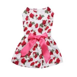 Elegant white summer pet dress featuring vibrant red floral patterns and a large pink satin bow