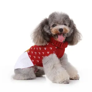 Gros plan d'un adorable chien portant un élégant pull d'hiver en tricot rouge et blanc.