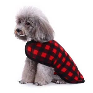 Piccolo cane con gilet invernale caldo a scacchi rossi e neri su sfondo bianco