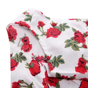Macro detail view showing red rose floral print and stitching on white pet summer dress fabric