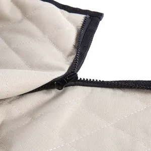 Detailed view of beige quilted pet car seat cover with black zipper, durable and practical.