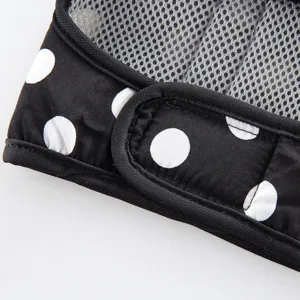 Dettaglio della pettorina per cani in rete traspirante a pois neri con chiusura in velcro e bordi.