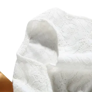 Close-up detail of the delicate white floral lace fabric on a cute pet summer dress