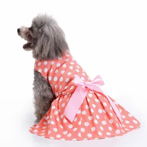 Detailed back view of a coral pink polka dot dog dress featuring a large pink satin bow