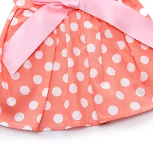 Detailed macro shot of a peach pink polka dot pet dress with a satin bow ornament