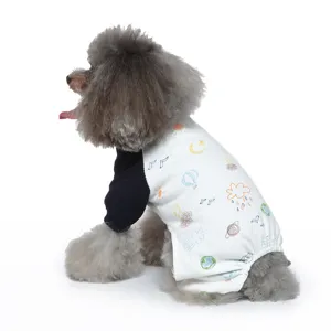 Seitenansicht eines Zwergpudels in einem weißen Hundepyjama mit bunten Kritzelmustern