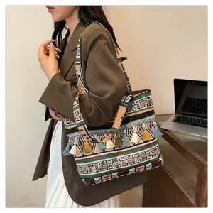 Primer plano de un bolso étnico con borlas coloridas y hermosos patrones bohemios.