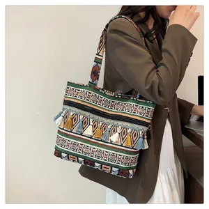 Vista detallada del bolso de hombro tejido de estilo étnico con borlas de colores